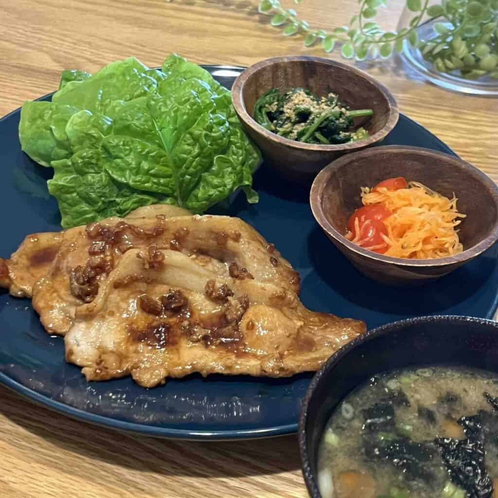 焼き上がった豚の生姜焼きがお皿に盛り付けられ机にのっている