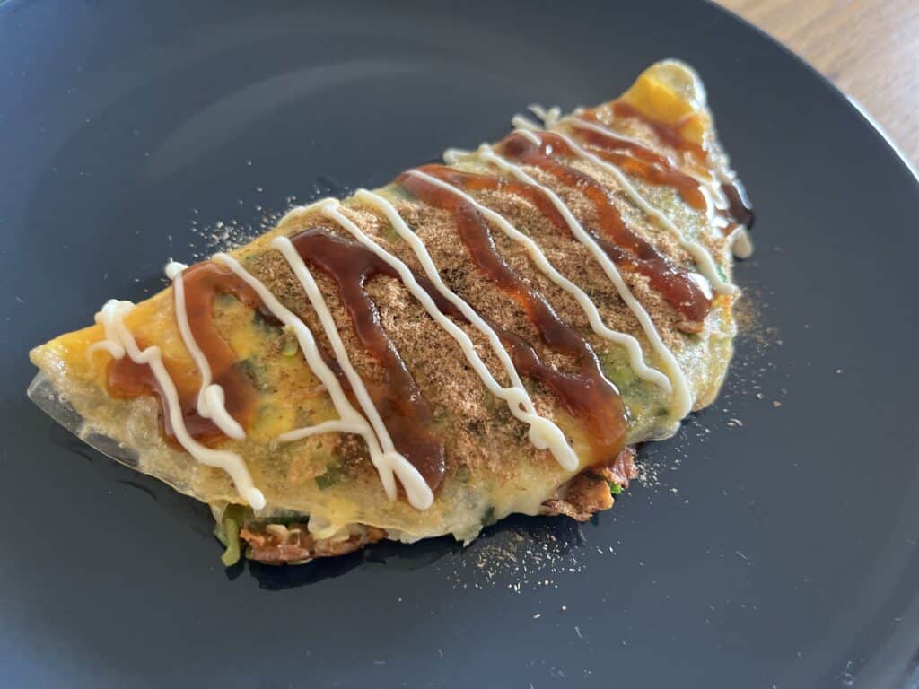 ライスペーパーで包んだニラとネギのお焼き。アミエビと魚粉を加えて旨味を引き出し、ソースとマヨネーズをトッピングした一品
