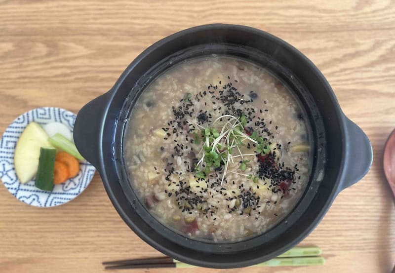 ほうじ茶で作った豆たっぷりの健康的なお粥が土鍋に入っている